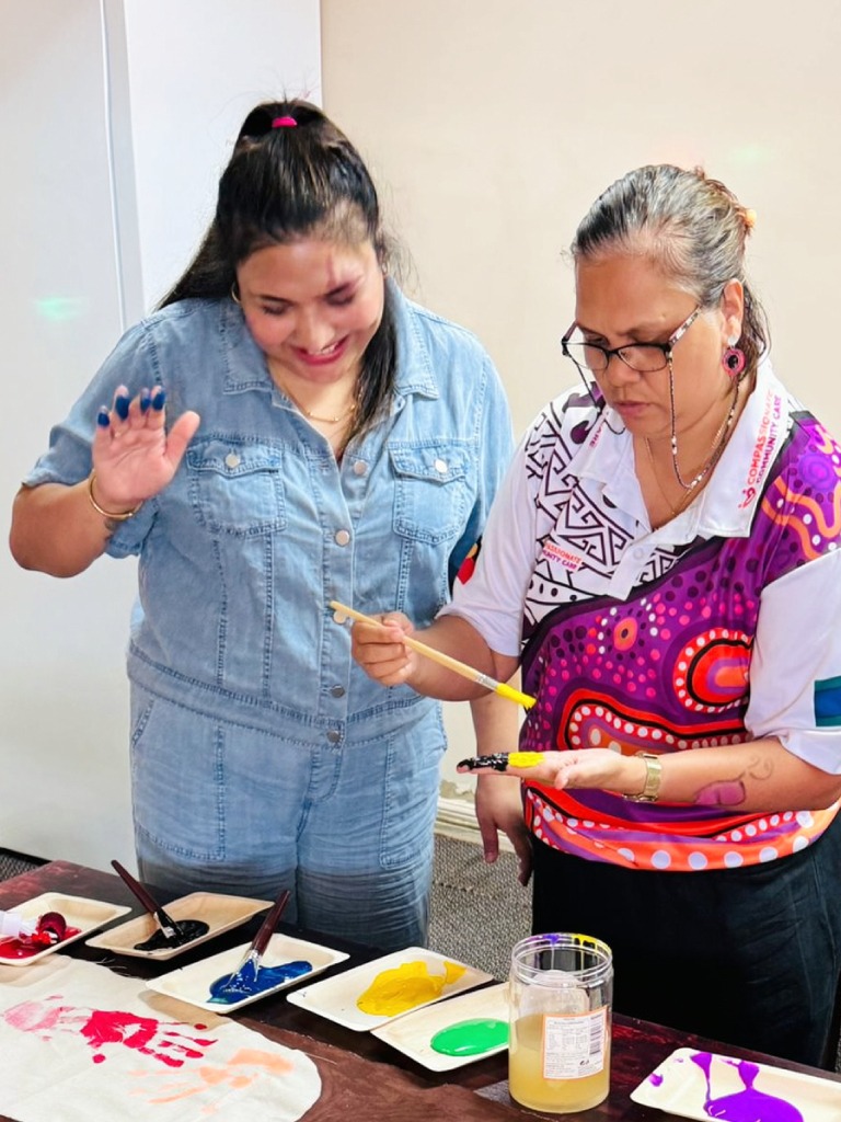 Support worker smiling with participant in a community setting