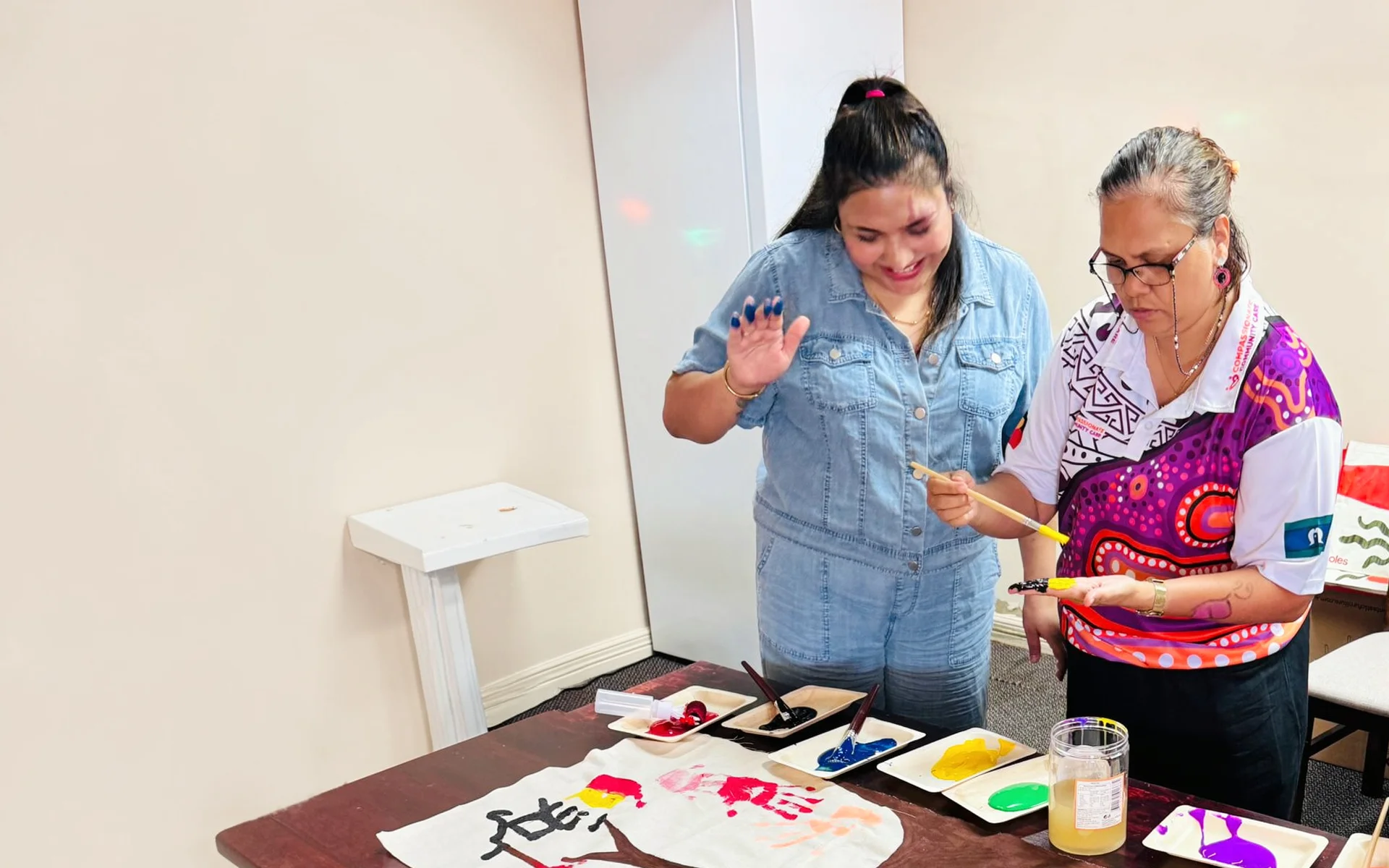 Support worker smiling with participant in a community setting